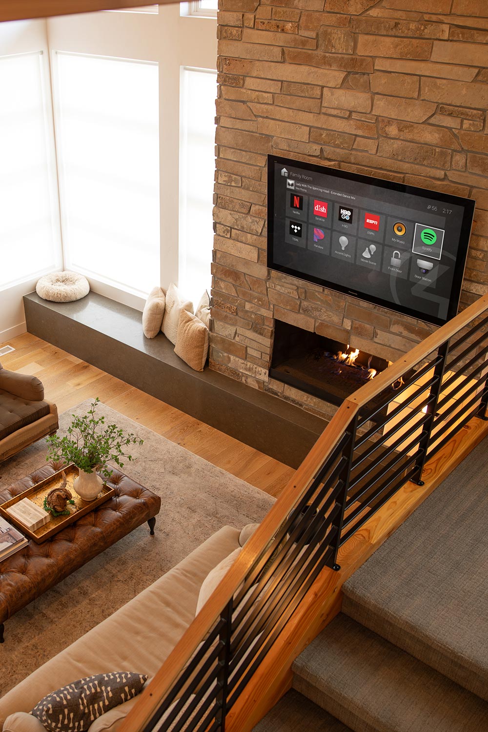 Living room with wall mounted display showing a smart home control interface